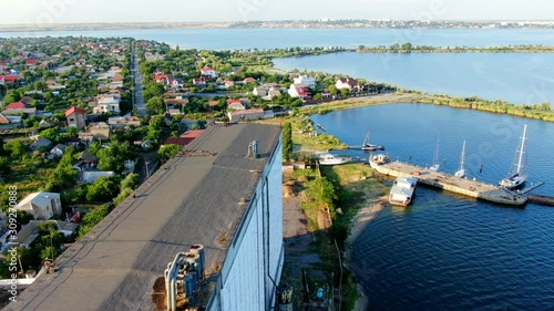 Mykolaiv/Ukraine - July 14, 2019. Aerial view of grain elevator builded in 1979 during soviet union. The type of elevator is very old. Capacity 35000 t. Also view of Ingul river.and boats and yachts. photo