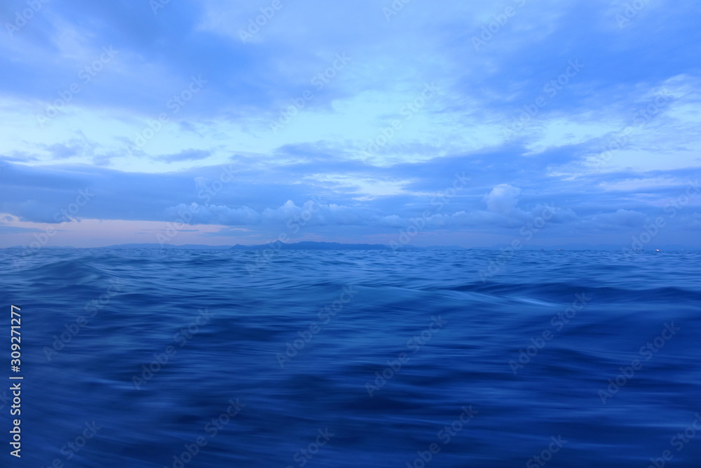 Dramatic dusk over the Aegean sea with beautiful colours and clouds as seen from cruising yacht in Cyclades isalands, Greece