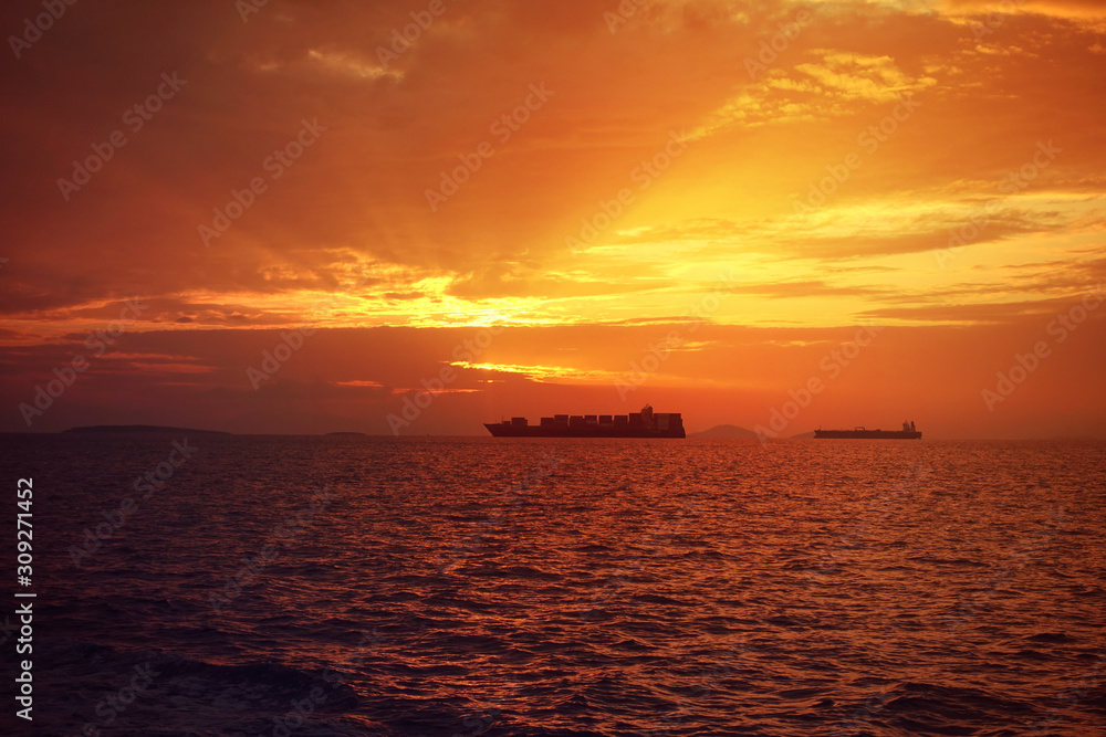 Romantic sunset over the Aegean sea with beautiful golden colours and clouds as seen from cruising yacht in Cyclades isalands, Greece