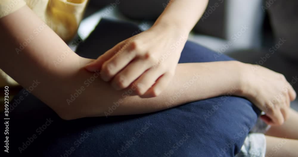 Asian woman itchy and scratch on her arm while sitting on a sofa at home. Asian woman itchy and scratch on her arm while sitting on a sofa at home.