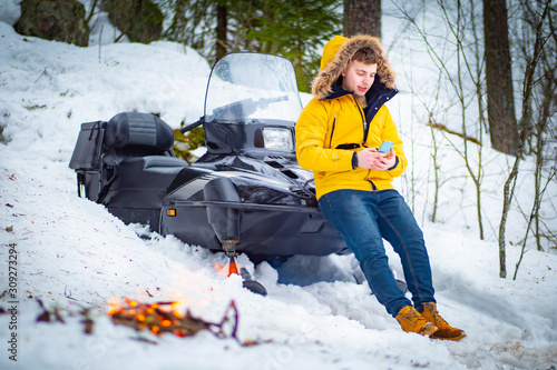 A man leans against a snowm...