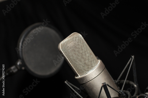 Microfono de condensador en estudio con antipop y fondo negro photo