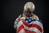 American soldier holding nationals flag in hands.