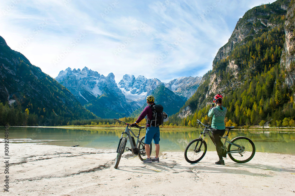 Two cyclists by the lake in the mountains