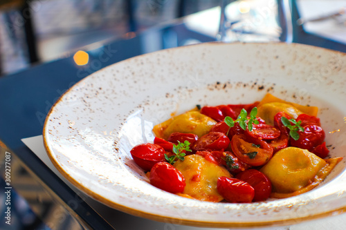 dish of handmade Caprese ravioli served with red corbarino cherry tomato and marjoram photo