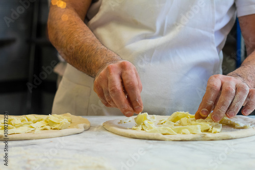 pizza chef at work creates a margherita pizza in an Italian pizzeria
