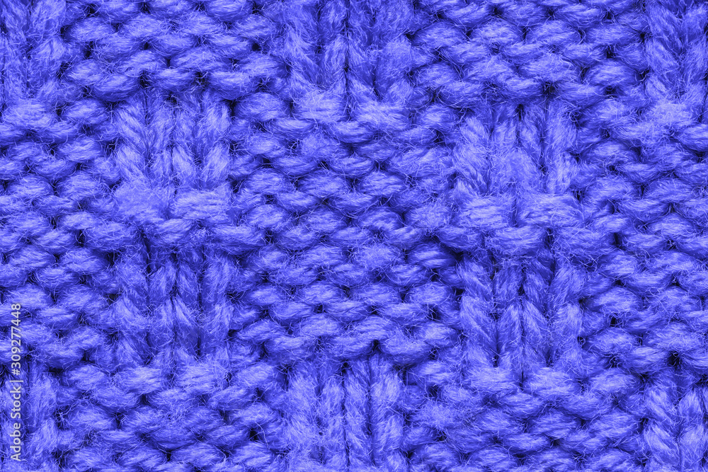 The texture of a knitted sweater. Blue pattern. Facial surface. Background. Copy space