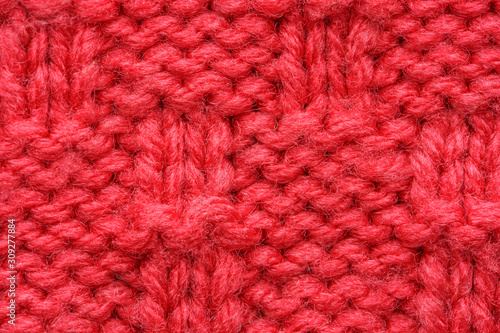 The texture of a knitted sweater. Red pattern. Facial surface. Background. Copy space