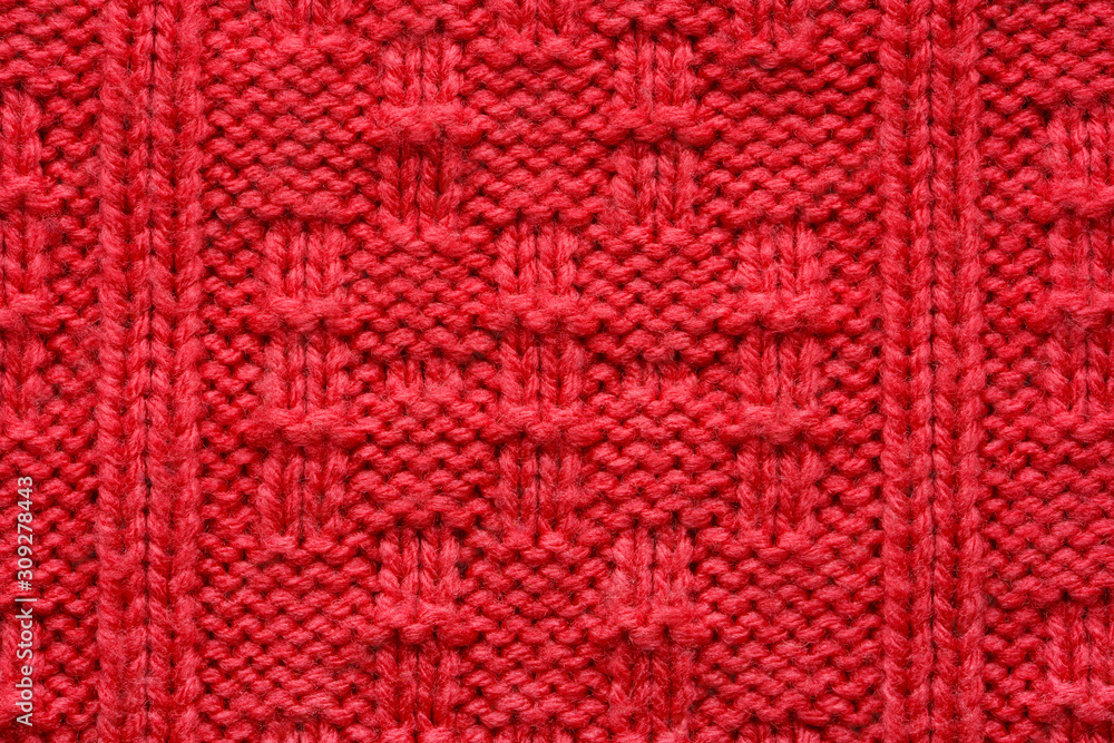 The texture of a knitted sweater. Red pattern. Facial surface. Background. Copy space