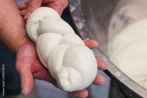 cheese maker creates a braid of buffalo mozzarella