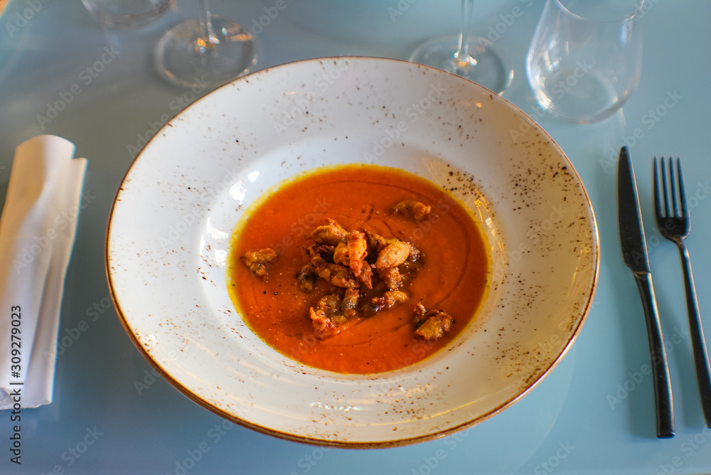 Neapolitan pumpkin soup, very special for its sweet taste, accompanied by fried squid, olive oil and oregano in a luxury Italian restaurant Neapolitan pumpkin soup, very special for its sweet taste, accompanied by fried squid, olive oil and oregano in a luxury Italian restaurant