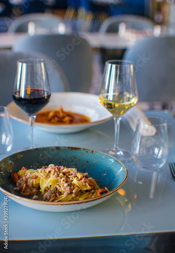 table for two with tagliolini seafood and wine glasses in a refined Italian restaurant