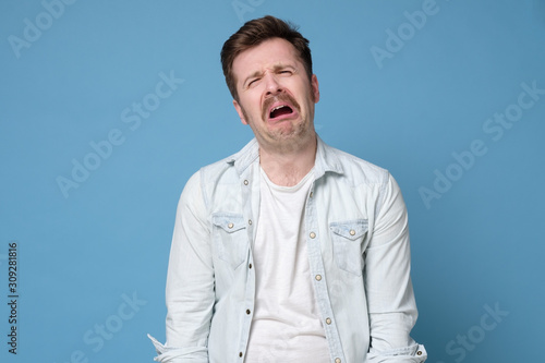 Photo Funny caucasian man crying wipes tears losing his job.