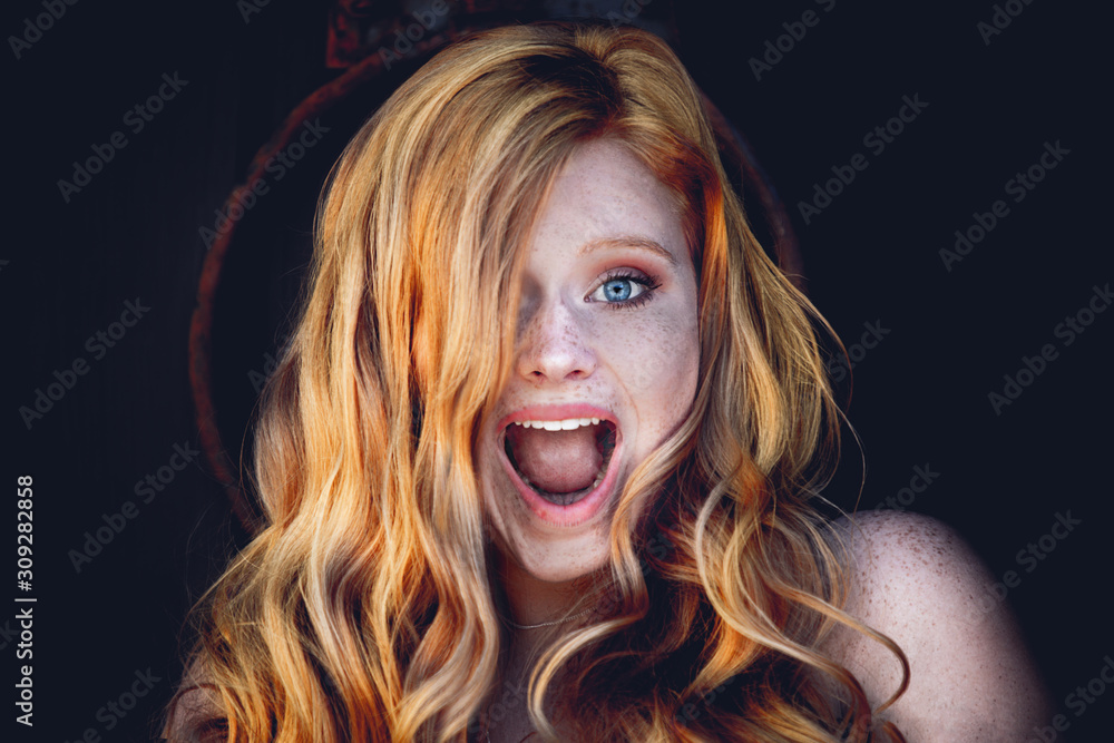 Portrait of a funny red haired young woman with freckles