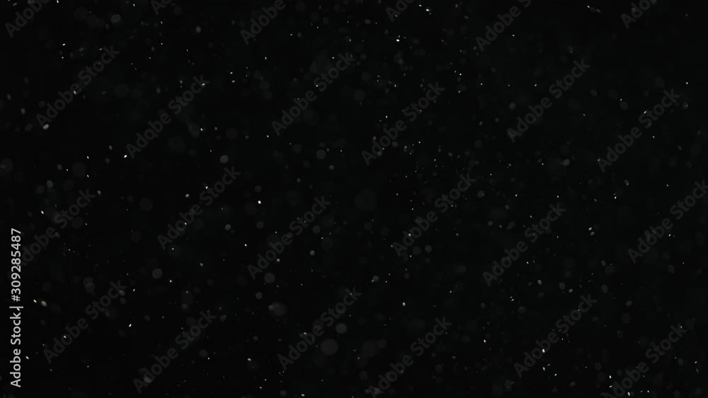 Natural organic dust particles on black background. Glittering Particles With Bokeh. Slow motion at 1000 fps. Natural organic dust particles on black background. Glittering Particles With Bokeh. Slow motion at 1000 fps.