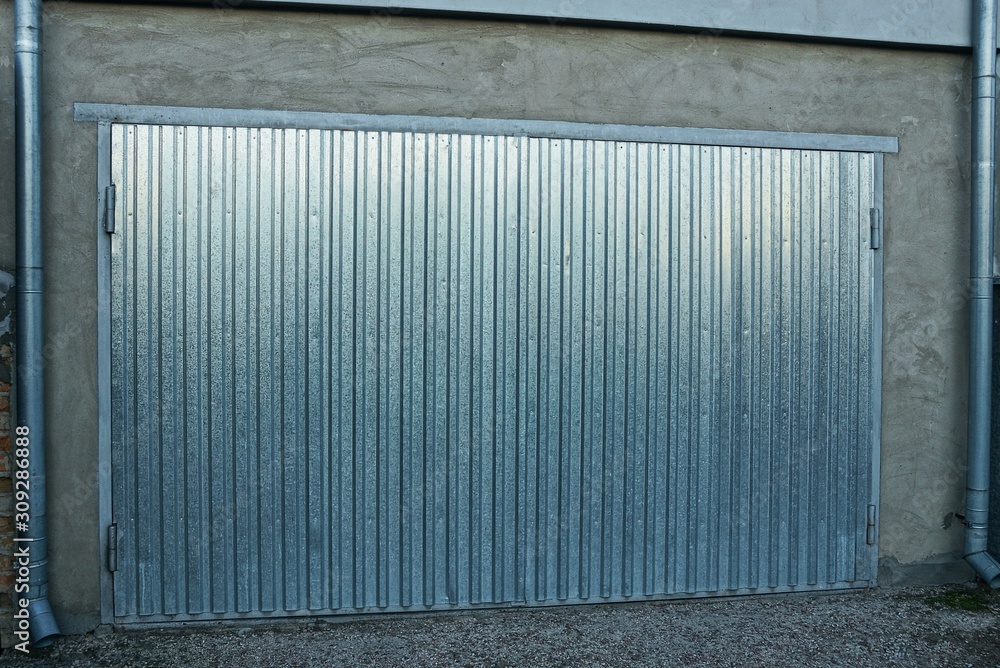 facade of a private one garage with gray metal gates in the street facade of a private one garage with gray metal gates in the street