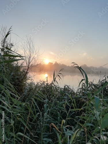 the sun rises over the river