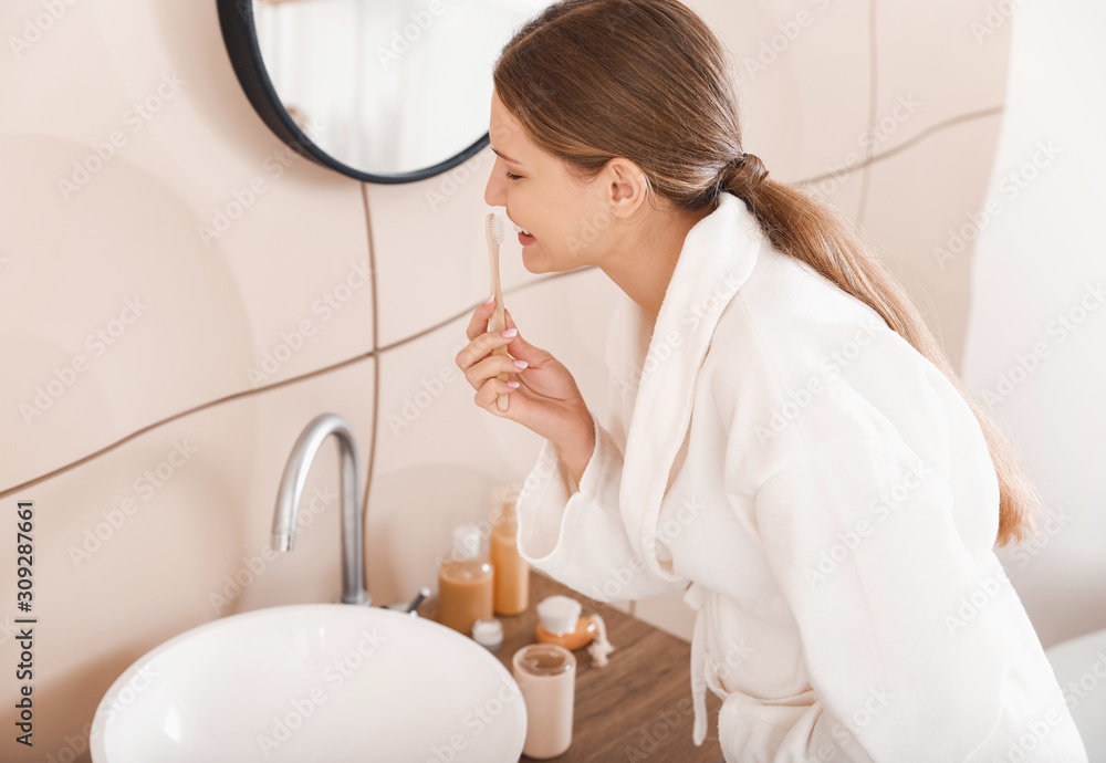 Young pregnant woman brushing teeth in bathroom Young pregnant woman brushing teeth in bathroom