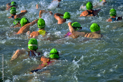 Women’s Triathlon swimming leg, all wearing green caps photo