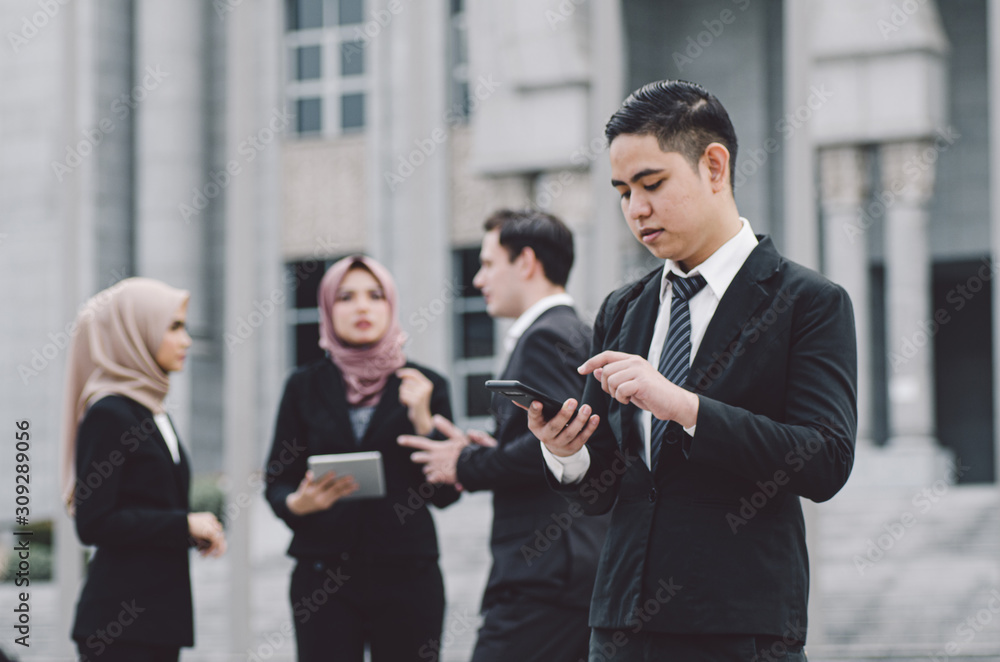 Portrait of young businessman Texting to Someone on his Mobile Phone with Happy Facial Expression. Portrait of young businessman Texting to Someone on his Mobile Phone with Happy Facial Expression.
