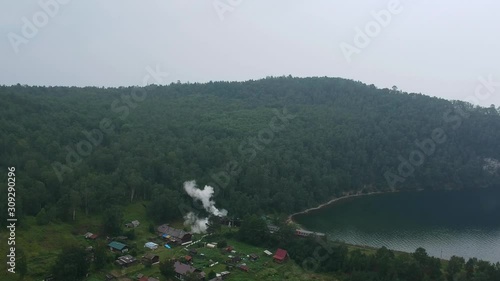 Aerial shot. The view from the drone on a train that travels on the TRANSSiberian railway. Lake Baikal, the nature of Russia. Green forest. photo