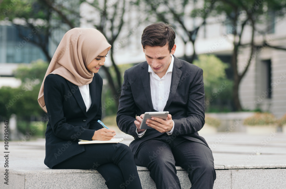 smiling face expression,young businesspeople in formalwear sitting outside their office and having discussion smiling face expression,young businesspeople in formalwear sitting outside their office and having discussion