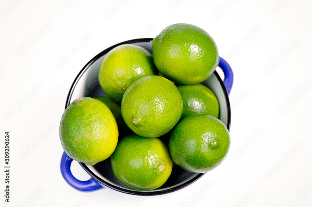Lime Citrus Fruits in a bowl over white background Lime Citrus Fruits in a bowl over white background