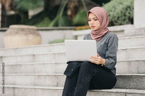 confident expression, young executive business woman sitting on stars and work with her laptop.focus on laptop