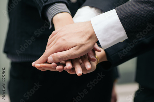 working together or team work concept.cropped image group of young business people with suit putting hands on top of hands. © amirul syaidi