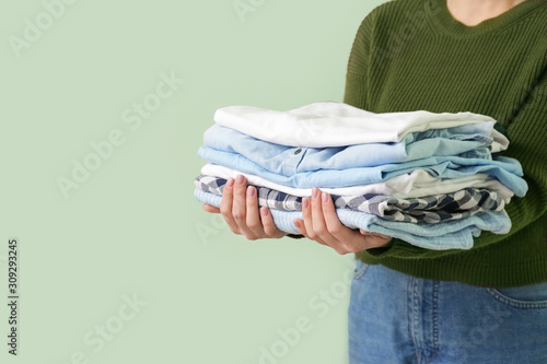 Young woman with clean clothes on color background, closeup