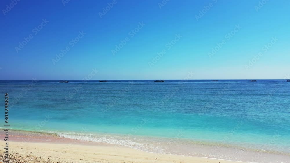 Quiet exotic beach with white sand washed by calm clear water of turquoise lagoon and blue sea horizon under bright sky in Thailand Quiet exotic beach with white sand washed by calm clear water of turquoise lagoon and blue sea horizon under bright sky in Thailand