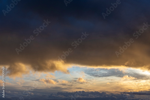 Dramatic sunset light reflect in dark storm clouds. © valdisskudre