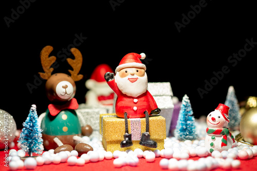 Santa Claus doll, pine tree, deer, snowman and gift box merry Christmas decoration on a bokeh light background with copy space