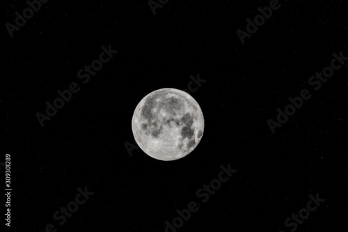 The full moon, the moon against the black starry sky.