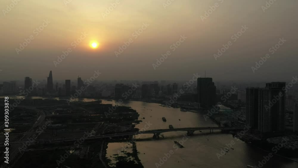 Drone shot of Saigon river smoggy sunset typical of a day with an extreme air pollution reading in Southeast Asia. High angle slow pan from right to left Drone shot of Saigon river smoggy sunset typical of a day with an extreme air pollution reading in Southeast Asia. High angle slow pan from right to left