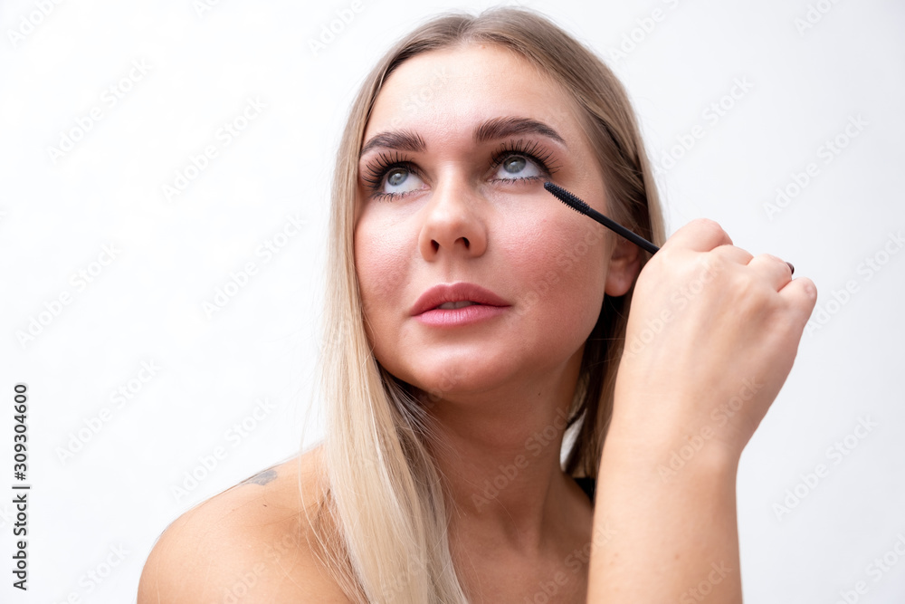 Beautiful girl applying mascara. Portrait of a beautiful girl applying mascara. Beautiful girl applying mascara. Portrait of a beautiful girl applying mascara.