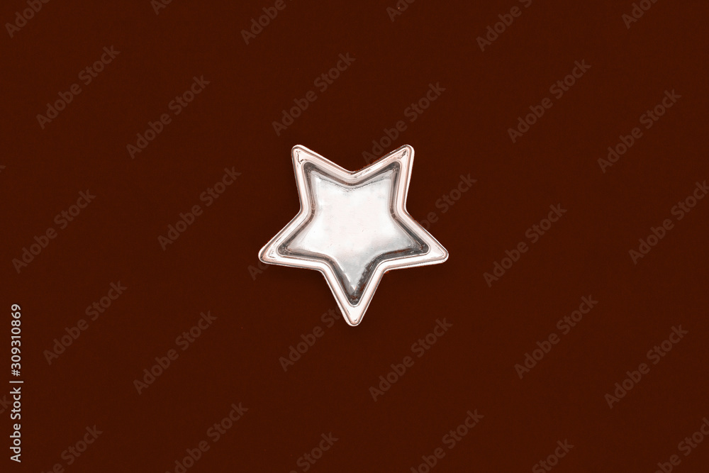 Christmas five pointed golden star on burgundy background. Christmas decoration. Christmas five pointed golden star on burgundy background. Christmas decoration.