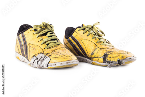 Old  worn out futsal sports shoes on white background soccer sportware object isolated