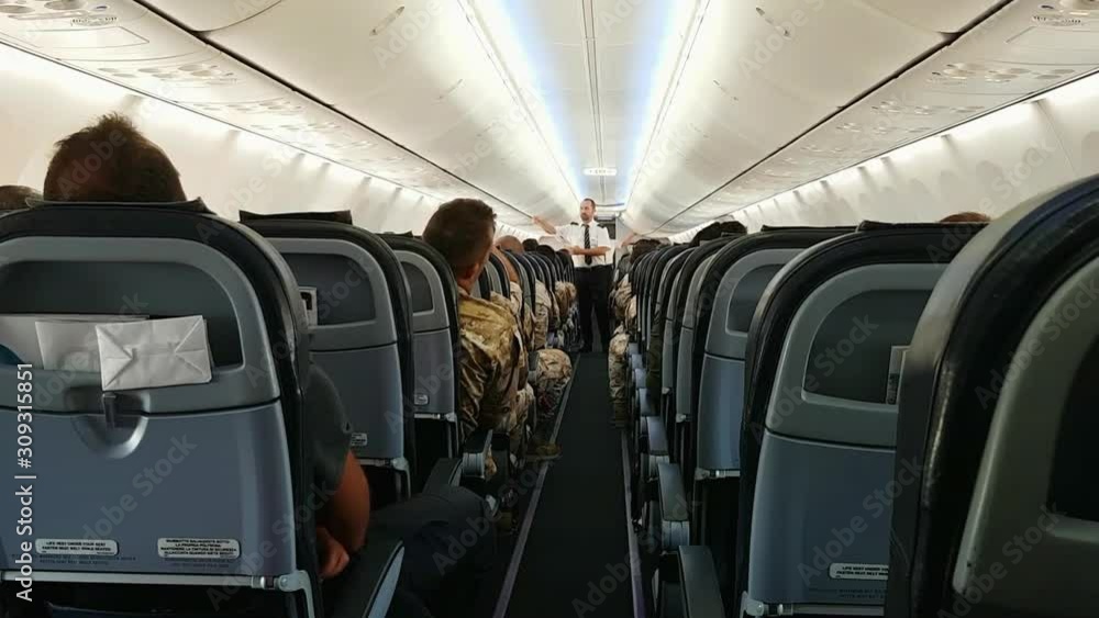 Steward shows passengers use of oxygen mask. Wide angle zoom out Steward shows passengers use of oxygen mask. Wide angle zoom out