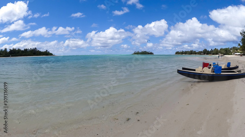twin hulled leisure boats sitting on the beach at Tropical Muri beach lagoon on a hot sunny day
