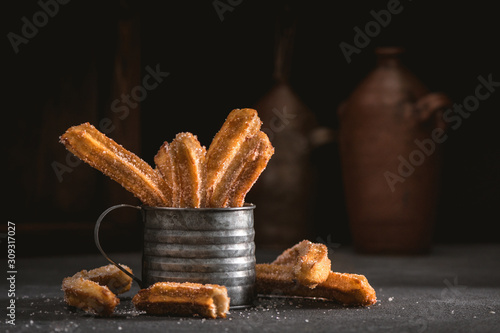 Traditional churros sticks with cinnamon and sugar powder photo
