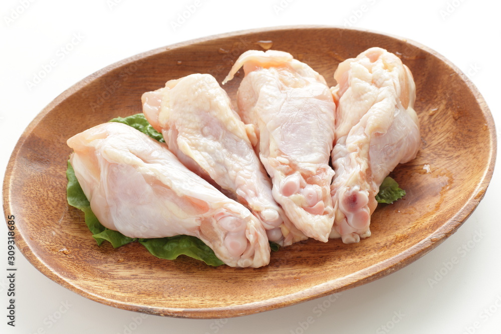 Chicken drumsticks on wooden plate with copy space