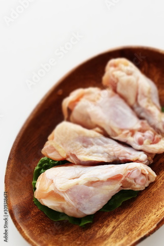 Chicken drumsticks on wooden plate with copy space