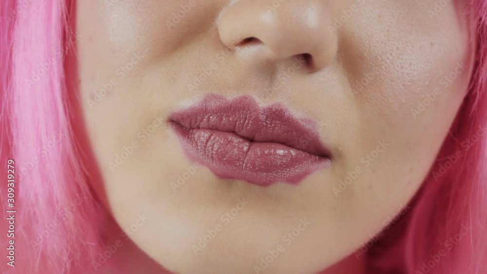Girl with the lips of the devil. Young beautiful girl with pink hair. A new trend in cosmetology Girl with the lips of the devil. Young beautiful girl with pink hair. A new trend in cosmetology