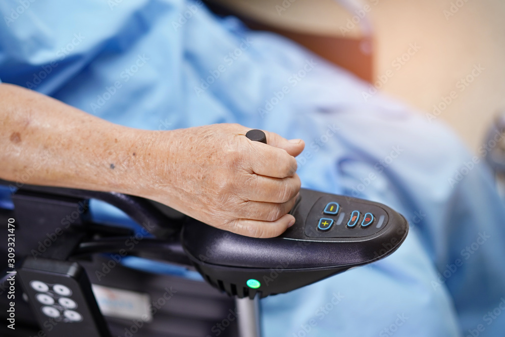 Asian senior or elderly old lady woman patient on electric wheelchair with remote control at nursing hospital ward : healthy strong medical concept .