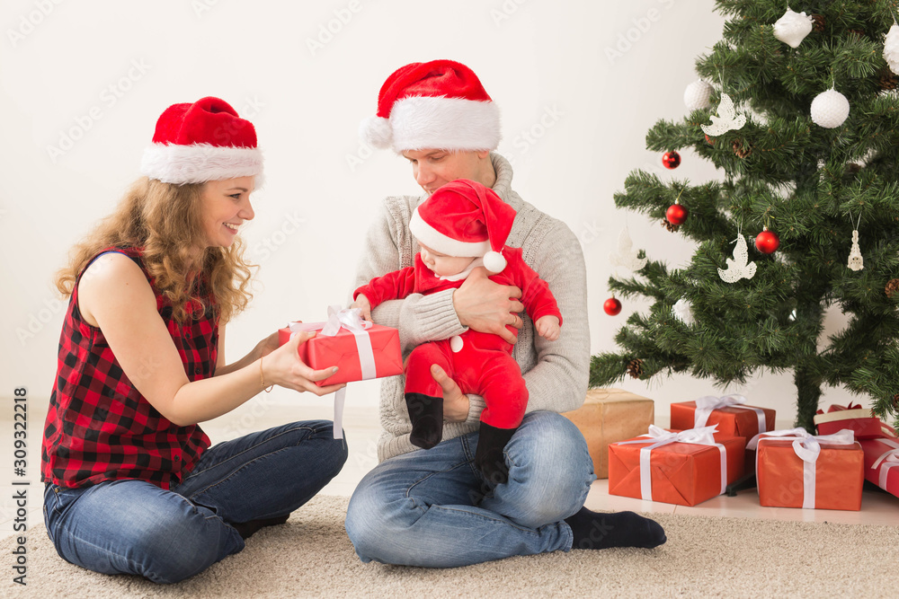 Happy couple with baby celebrating Christmas together at home. Happy couple with baby celebrating Christmas together at home.