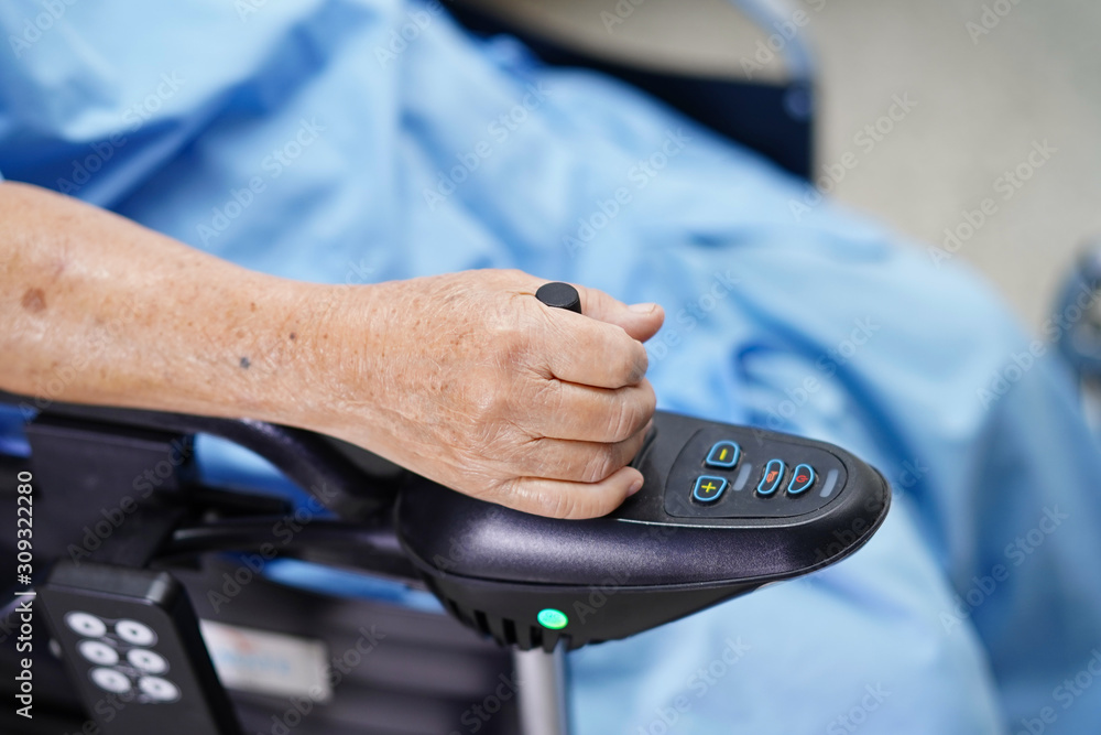 Asian senior or elderly old lady woman patient on electric wheelchair with remote control at nursing hospital ward : healthy strong medical concept 