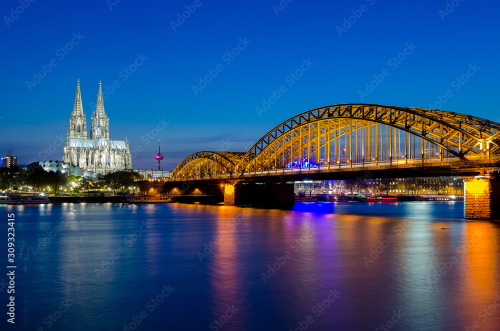 Fototapeta premium Hohenzollern bridge with t Cologne Cathedral and Rhine river during sunset in Cologne, Germany. Europe tourism, history building, or tradition culture and travel concept