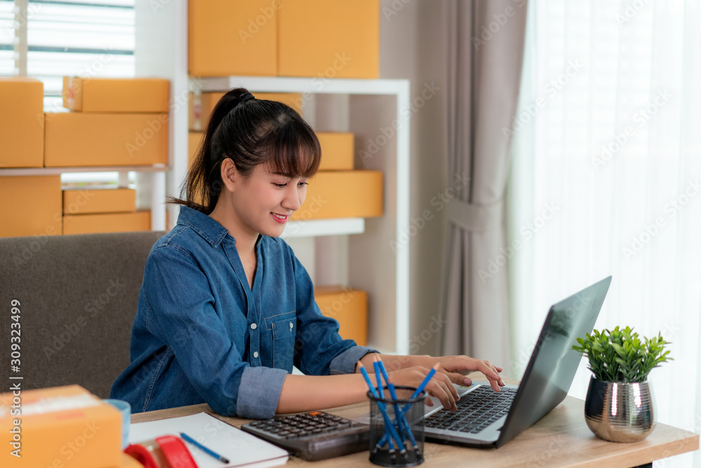 Charming beautiful Asian teenager owner business woman work at home for online shopping, looking the order in laptop with office equipment, entrepreneur lifestyle concept Charming beautiful Asian teenager owner business woman work at home for online shopping, looking the order in laptop with office equipment, entrepreneur lifestyle concept