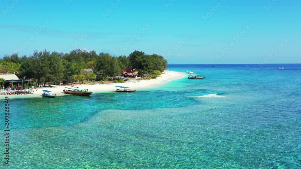 Calm crystal water of shallow lagoon with blue turquoise colors around white sand of exotic beach where touring boats anchoring in Bali Calm crystal water of shallow lagoon with blue turquoise colors around white sand of exotic beach where touring boats anchoring in Bali